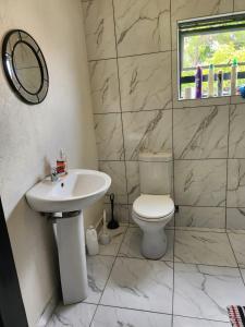 a bathroom with a white toilet and a sink at Ezcel accommodation in Cape Town