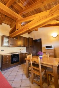 Leverogne RochefortMaison Godioz - Appartamento 7的厨房设有木桌和木制天花板。