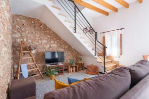 a living room with a couch and a tv at Ca Ses Nines in Ariany