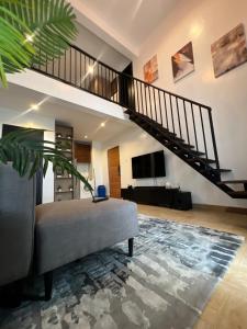 a living room with a staircase and a couch at COC00N by IVY in Lagos