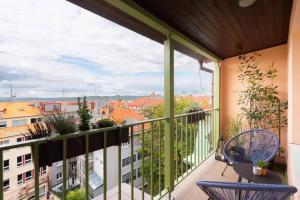 a balcony with chairs and a view of a city at Huge 5-bedrooms apartment near Prague Castle in Prague