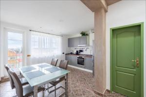 a green door in a kitchen with a table and chairs at Huge 5-bedrooms apartment near Prague Castle in Prague
