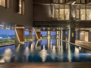 an indoor pool in a building with a view at Herloom Hotel & Residence BSD Tangerang in Tangerang