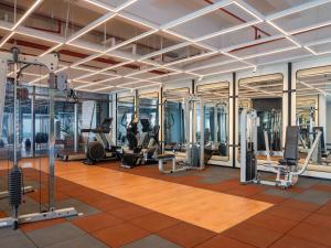 un gimnasio con cintas de correr y elípticas en un edificio en Herloom Serviced Residence BSD en Tangerang