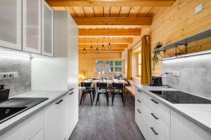 a kitchen with white cabinets and a table with chairs at Gabreta apartments in Stachy