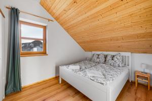 Posto letto in camera con soffitto in legno. di Gabreta apartments a Stachy