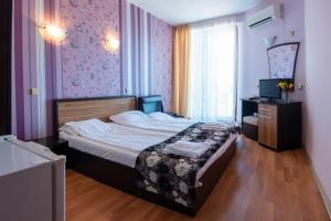 a bedroom with a bed and a television in it at South Beach Hotel - New Management and Free Beach Access in Tsarevo +61 photos