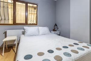 1 dormitorio con 1 cama blanca y ventana en Flat with Backyard 6 min to Bostanci Show Center en Estambul