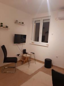 a living room with a tv and a chair and a table at BelDor Apartment in Belgrade