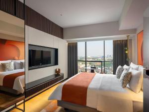 a hotel room with a bed and a large window at Herloom Hotel & Residence BSD Tangerang in Tangerang