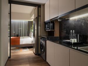 a kitchen with a washer and dryer in a room at Herloom Hotel & Residence BSD Tangerang in Tangerang