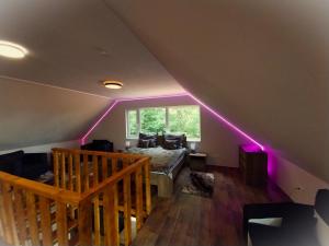 a room with a bed and a window with purple lights at HUNOR Vendégház in Sátoraljaújhely