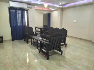 a salon with black chairs and tables in a room at vinoth in Mannārgudi