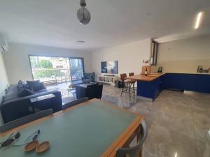 a living room with a couch and a table at Renovated central 4 bedroom apt with great terrace and Bomb Shelter in Ramat Gan