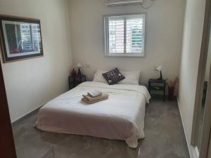 - une chambre avec un lit et 2 serviettes dans l'établissement Renovated central 4 bedroom apt with great terrace and Bomb Shelter, à Ramat Gan