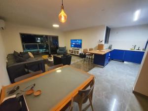 a large living room with a table and a kitchen at Renovated central 4 bedroom apt with great terrace and Bomb Shelter in Ramat Gan