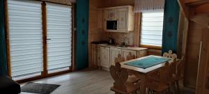 a kitchen with a table and chairs and windows at Domek Góralski w Jurgowie in Jurgów