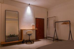 sypialnia z lustrem i krzesłem w obiekcie Sewaro Homestay, Vista Suite. w Aizawl