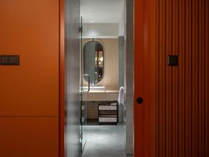 a bathroom with a sink and a mirror at Herloom Hotel & Residence BSD Tangerang in Tangerang