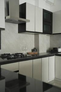 eine Küche mit weißen Schränken und einer schwarzen Arbeitsplatte in der Unterkunft Sewaro Homestay, Vista Suite. in Aizawl
