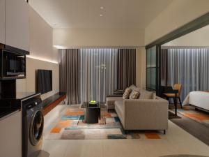 a living room with a couch and a bed at Herloom Hotel & Residence BSD Tangerang in Tangerang