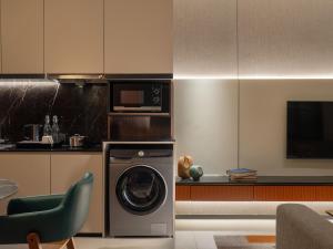 a kitchen with a washing machine and a microwave at Herloom Hotel & Residence BSD Tangerang in Tangerang