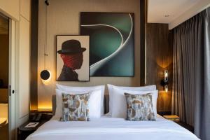 um quarto com uma cama com um chapéu e almofadas em Herloom Serviced Residence BSD em Tangerang