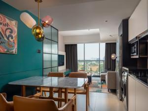 Herloom Hotel & Residence BSD Tangerang في تانغيرانغ: مطبخ وغرفة طعام مع طاولة وكراسي