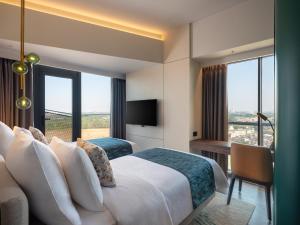 a hotel room with a bed and a large window at Herloom Hotel & Residence BSD Tangerang in Tangerang