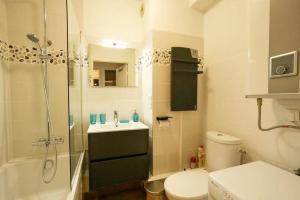 een badkamer met een douche, een toilet en een wastafel bij Le Balmoral - Plage à 1 min - ménage inclus - terrasse lumineuse in Wimereux