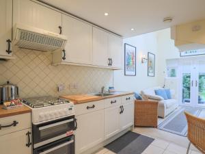a kitchen with white cabinets and a stove top oven at Pass the Keys Cosey 3 Sleeper Flat in Winkfield in Winkfield