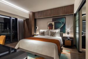 a bedroom with a large bed and a large window at Herloom Hotel & Residence BSD Tangerang in Tangerang