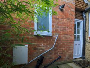 a brick house with a white door and a window at Pass the Keys Cosey 3 Sleeper Flat in Winkfield in Winkfield