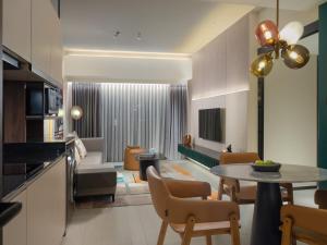 a kitchen and living room with a table and chairs at Herloom Hotel & Residence BSD Tangerang in Tangerang