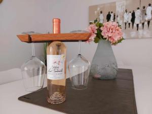 uma garrafa de vinho numa mesa com dois copos de vinho em Duplex Villa Capricia appartement met zwembad Nieuwpoort Jachthaven em Nieuwpoort