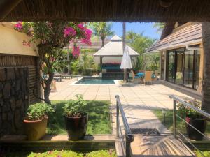 um pátio com vasos de plantas e uma piscina em Exotic Oasis Villa In The Tropics em Grand Baie