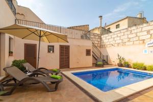 - une piscine avec mobilier de jardin et parasol dans l'établissement Villa Placeta 6, à Sa Pobla