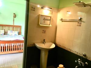 a bathroom with a sink and a bed at Panthalams Homestay in Thekkady