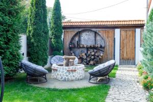 a garden with a fountain and two chairs and a fire place at The River Chalet in Sibiel
