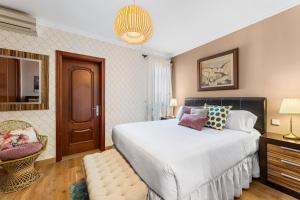 a bedroom with a large bed and a chair at Lanzarote Villa Aira in Playa Honda