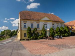 a yellow building with a roof on a street at Hotel Club in Vranovská Ves