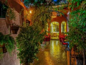 un corridoio con piante, tavolo e sedie di Riad Dar Sido a Marrakech