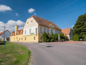 a large yellow building on the side of a street at Hotel Club in Vranovská Ves