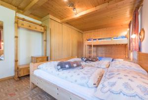 um quarto com uma cama grande num quarto de madeira em Almliesl HOLL-154 em Hollersbach im Pinzgau