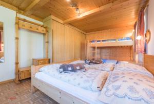 a bedroom with a large bed in a wooden room at Almliesl HOLL-154 in Hollersbach im Pinzgau