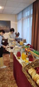 a group of people standing around a buffet line with food at Canada Hotel Budapest in Budapest