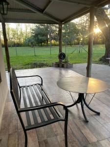 a bench and a table on a patio at Mi paraíso verde in Junín