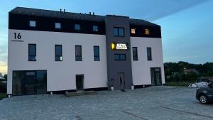 a large white building with a sign on it at AZYL in Legnica