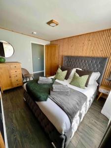 a bedroom with a large bed with green pillows at Luxury lodge, foot of South Downs nr beach in Ferring