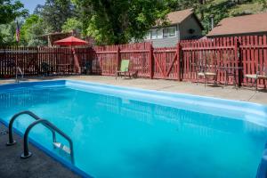 una piscina blu accanto a una recinzione rossa di A-Lodge Boulder a Boulder